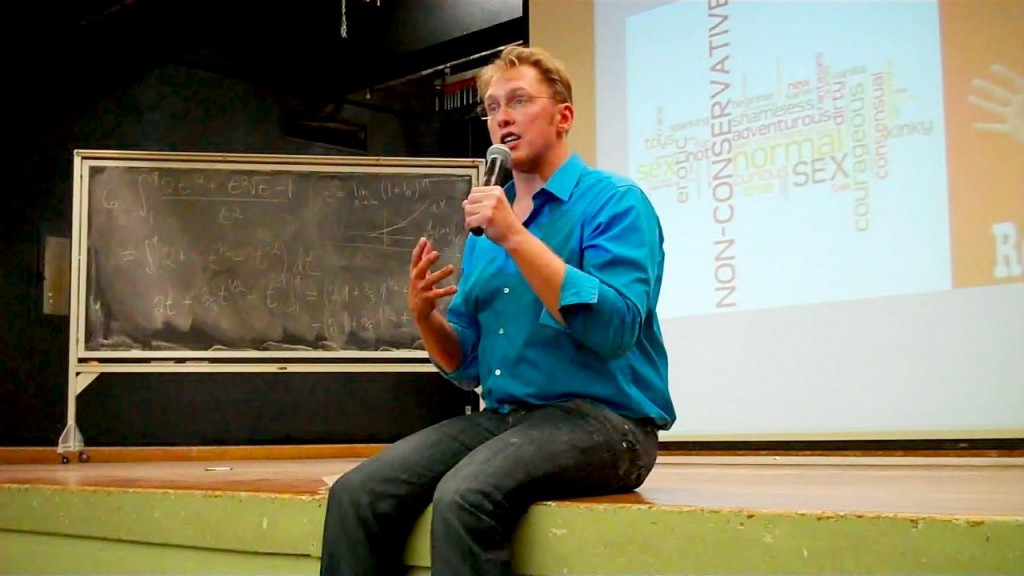 Sex and relationship expert Reid Mihalko sitting on stage at a recent college lecture
