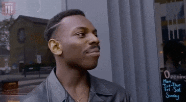 GIF of a confident African American man pointing to his temple and tapping it in a "think about it, be smart" gesture