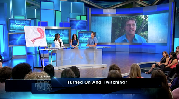 CBS' The Doctors health show with three commentators on stage at the desk and, behind them, on the big screen, via satellite, sex and relationship educator Reid Mihalko of ReidAboutSex.com wearing a blue, button down shirt.