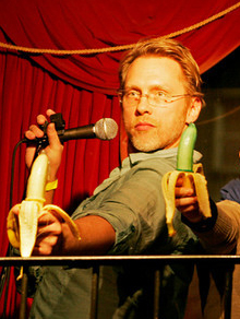 Sex and Relationship Expert Reid MIhalko doing a bit of Stand-Up Sex Education by deepthroating a condom-covered banana