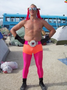 Sex and relationship expert Reid Mihalko at Burning Man 2007 wearing pink and orange spandex tights, goggles, yarn pigtails, and a donut utility belt