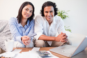 Young couple doing online banking in the living room