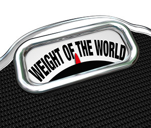The words Weight of the World on a scale to illustrate trouble,