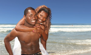 African American Couple Smiling On The Beach Outdoors