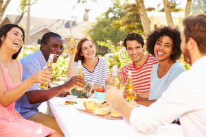 Group Of Friends Enjoying Meal At Outdoor Party In Back Yard