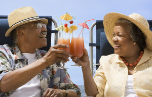 Senior African couple toasting with tropical cocktails