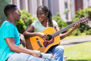 beautiful african girl playing guitar for her boyfriend
