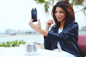 Female taking a picture of herself on smartphone while sitting i