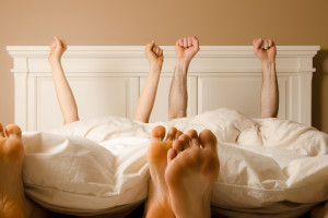 image of a couple with their hands up in bed