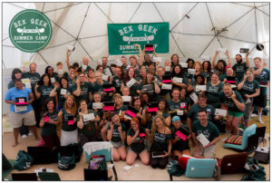 Group camp photo of Sex Geek Summer Camp's 75 sex educators each proudly holding their camp swag: Njoy sex toys