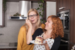Delighted Girlfriends Eating Cake In The Kitchen