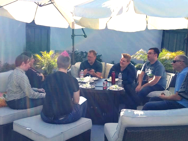 Sex and relationship educator Reid Mihalko of ReidAboutSex.com sitting outside beneath deck umbrellas with five other sex educators discussing business strategies