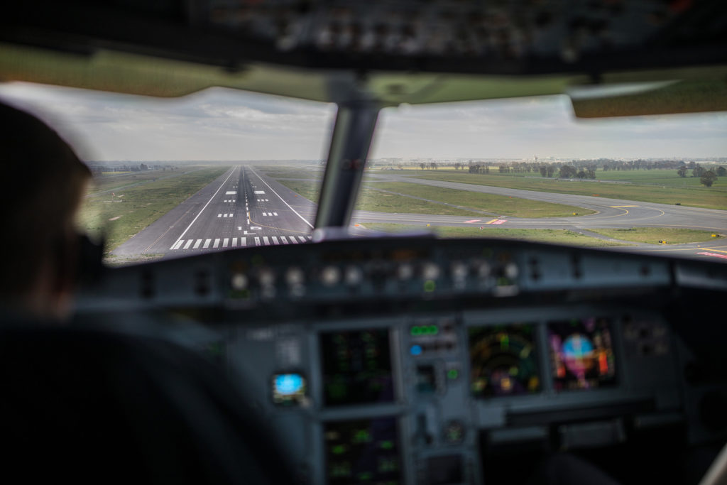 Pilot's view from a commercial airliner airplane flight cockpit during approach/landing