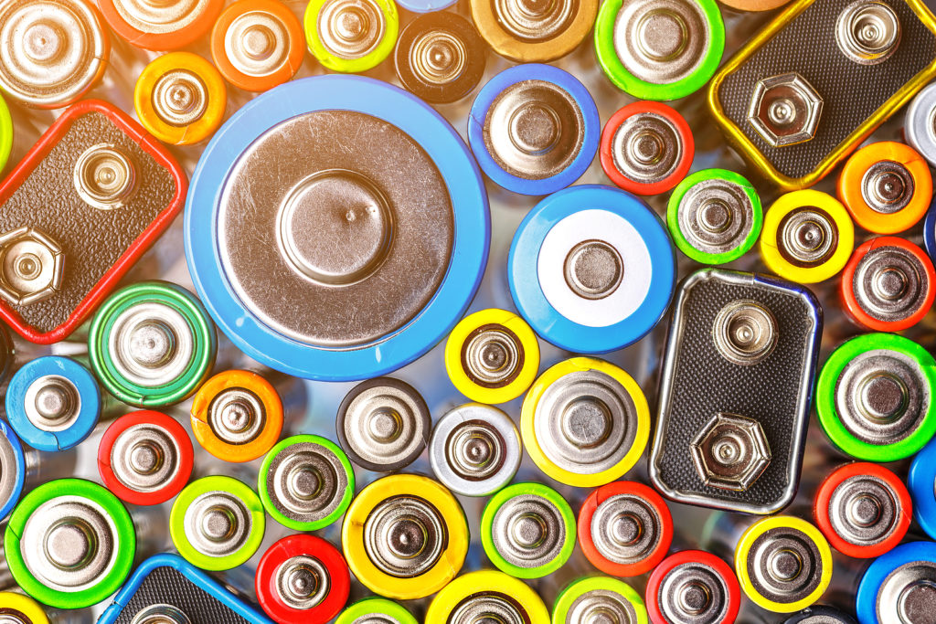 Energy abstract background of colorful batteries. Old used batteries ready for recycling. Used batteries from different manufacturers, waste, collection and recycling, Alkaline battery aa size.