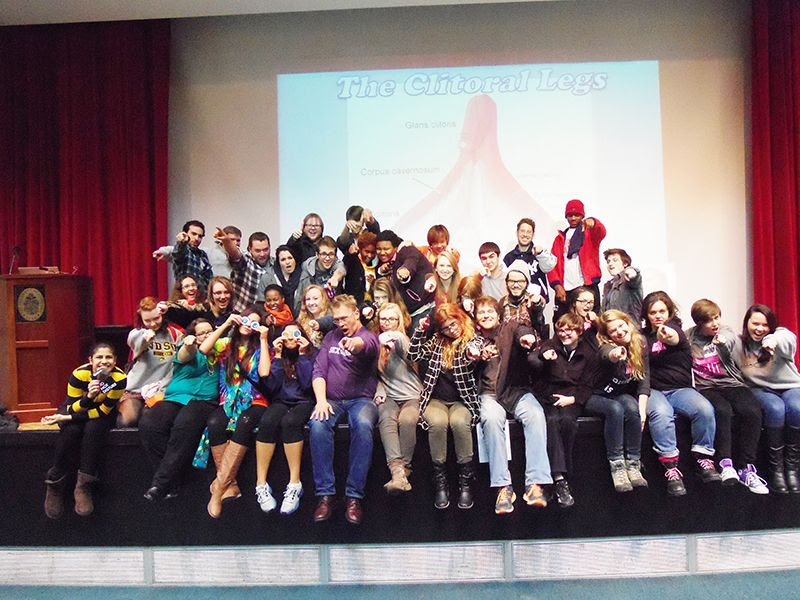 Reid with a large group of college students in front of a giant clitoris on a projector screen.