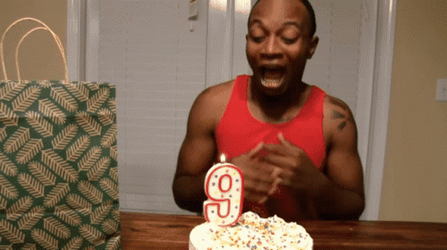 Person smashing their face into a  birthday cake GIF