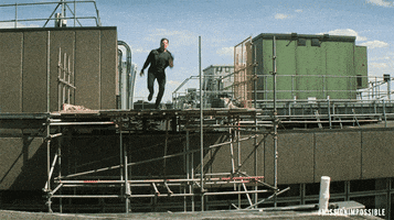 Tom Cruise leaping from building to building in Mission Impossible — Fallout movie GIF